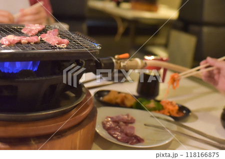 焼肉を焼く網とナムルを取る手 118166875