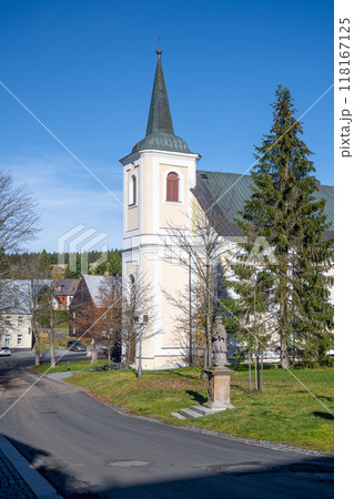 Saint Anne Church stands proudly in Bozi Dar, surrounded by trees and quaint buildings under a clear blue sky. Visitors can appreciate its architecture and the serene atmosphere of the Ore Mountains. Saint Anne Church stands proudly in Bozi Dar, surrounded by trees and quaint buildings under a clear blue sky. Visitors can appreciate its architecture and the serene atmosphere of the Ore Mountains. 118167125