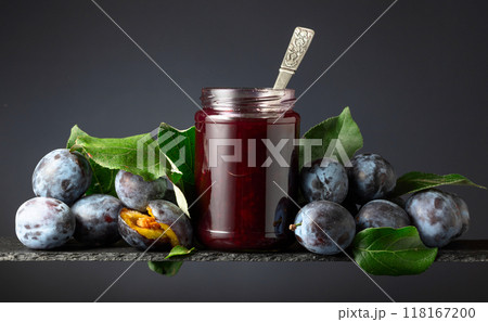 Plum jam and fresh berries on a black background. Plum jam and fresh berries on a black background. 118167200