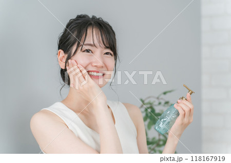 スキンケア・紫外線対策・美白・保湿をする椅子に座った笑顔のアジア人女性 118167919