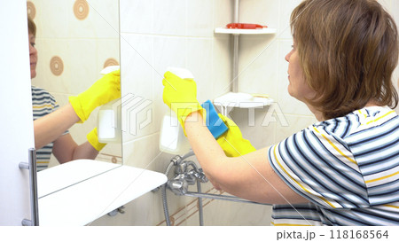 Young Woman Cleaning Bathroom Walls with Yellow Gloves - Housekeeping and Apartment Cleaning Young Woman Cleaning Bathroom Walls with Yellow Gloves - Housekeeping and Apartment Cleaning 118168564