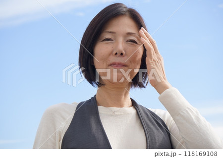 青空の下で寛ぐシニア女性 118169108