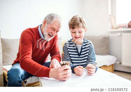 Grandfather spending time with grandson, taking care of him while parents are at work. Boy and grandpa drawing together. Grandfather spending time with grandson, taking care of him while parents are at work. Boy and grandpa drawing together. 118169572