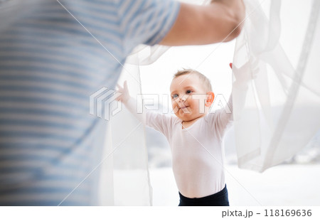 Dad playing with little son, hiding behind curtains. 118169636