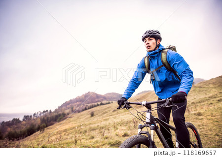 Active man on bike in the middle of beautiful nature, early autumn morning. Concept of healthy lifestyle. 118169657