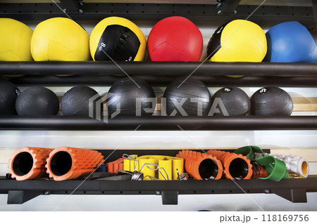 Rows of gym equipment, rubber medicine balls on racks for strength training in gym. Rows of gym equipment, rubber medicine balls on racks for strength training in gym. 118169756