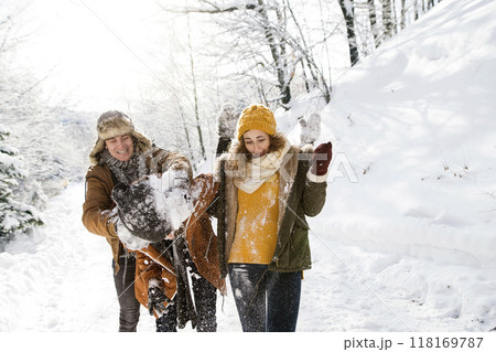 Friends in snowball fight in snowy nature. First snowfall of the season. 118169787