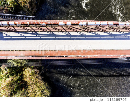 Aerial view of running trail with metal bridge over river. Running training, no people. 118169795