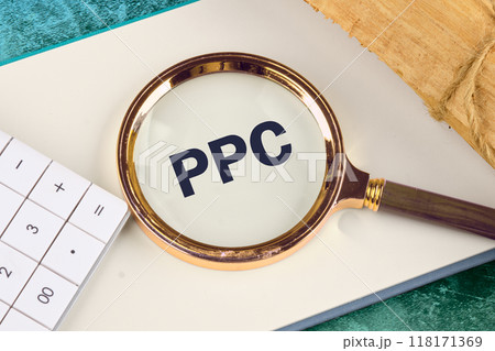 PPC. Pay Per Click concept Businessman working concept, social network, SEO. PPC written through a magnifying glass in a business book 118171369