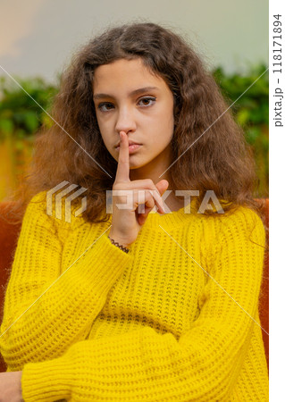 Teenager child girl presses finger to lips makes silence hush sign do not tell gossip secret, quiet 118171894
