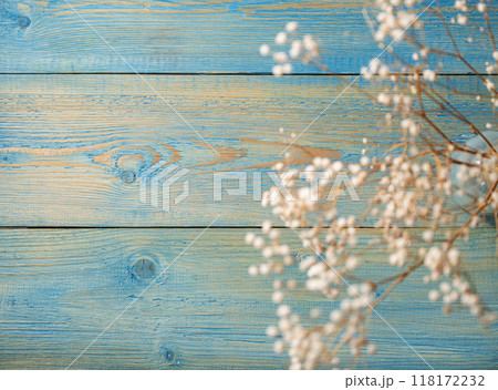 Dry white gypsophila flowers in a glass vase on a blue textured wooden background Dry white gypsophila flowers in a glass vase on a blue textured wooden background 118172232