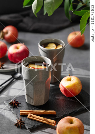 Homemade apple punch or cider with apples and cinnamon in gray cups on a dark background  118172612