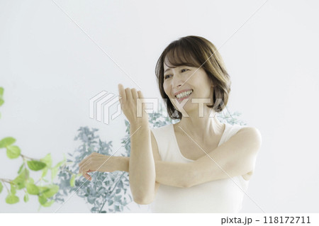 室内でストレッチするミドルエイジの女性 室内でストレッチするミドルエイジの女性 118172711