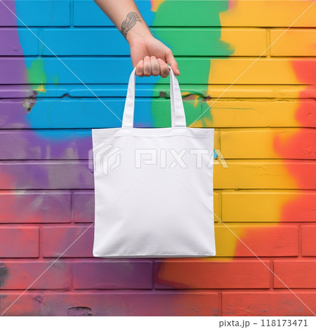 Mockup empty, a personal hand holding a white blank tote bag, organic shapes on the colorful background 118173471