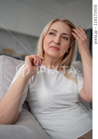 A woman is peacefully lounging on a couch in a contemporary home with simple and clean design A woman is peacefully lounging on a couch in a contemporary home with simple and clean design 118173938