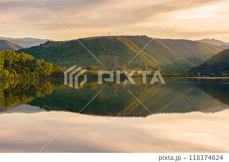 mountain landscape at the lake in autumn. trees in colorful foliage on the shore. beautiful nature view on a sunny sunset. scenery reflecting on the rippled water surface mountain landscape at the lake in autumn. trees in colorful foliage on the shore. beautiful nature view on a sunny sunset. scenery reflecting on the rippled water surface 118174624