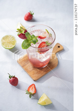 Fresh strawberry mojito in a glass with berries, lime, mint and ice on a light background Fresh strawberry mojito in a glass with berries, lime, mint and ice on a light background 118174737