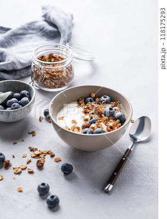 The concept of a healthy breakfast of yogurt, granola and fresh blueberry on a light background The concept of a healthy breakfast of yogurt, granola and fresh blueberry on a light background 118175293