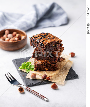 A stack of chocolate brownies with mint, hazelnuts and salted caramel on baking paper A stack of chocolate brownies with mint, hazelnuts and salted caramel on baking paper 118175298