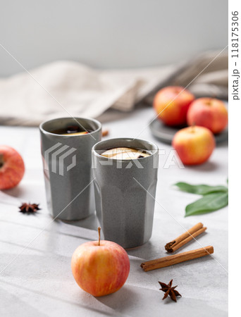 Homemade apple punch with apples and cinnamon in gray cups on a light background  118175306