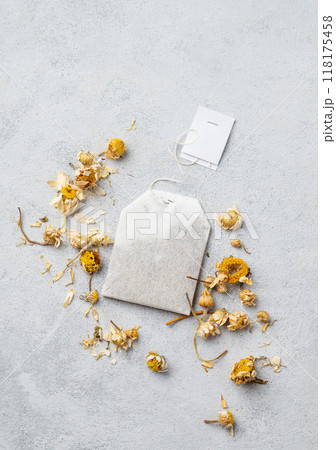 Dried chamomile in a tea bag on a light background. Healthy food and drink concept.  118175458