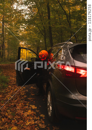 Autumn SUV with Driver with Pumpkin Head in Forest 118176258