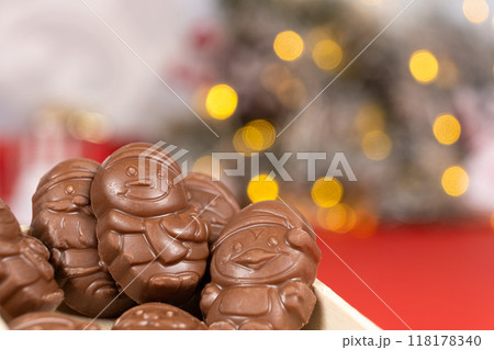 Chocolates in the shape of Christmas figures on the background of a flashing garland Chocolates in the shape of Christmas figures on the background of a flashing garland 118178340
