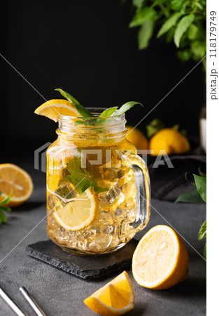 Lemonade drink with fresh lemon, mint and ice in a jar. Refreshing citrus mojito cocktail Lemonade drink with fresh lemon, mint and ice in a jar. Refreshing citrus mojito cocktail 118179749