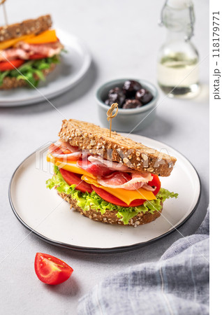 Toast club sandwich made of grain bread with cheddar cheese and bacon stuffed with tomatoes 118179771