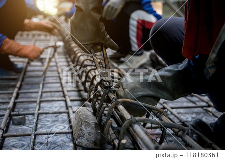 A group of builders is busy constructing a metal structure 118180361