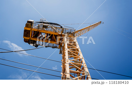 A large yellow crane stands out against a bright blue sky A large yellow crane stands out against a bright blue sky 118180410