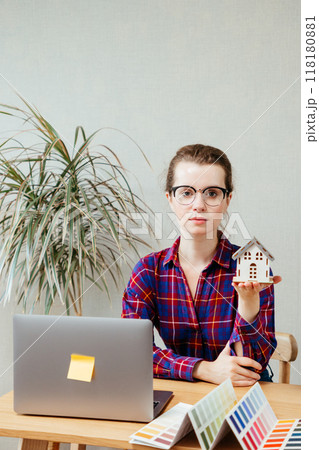 female architect is holding mock-up house, scale model building, thinking sketch for design courses.  118180881