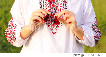 A banner design featuring a traditional Ukrainian vyshyvanka, embroidered shirt, showcased with hands holding the garment. Banner for design 118181660