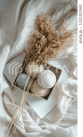 Neutral Wool Yarn Balls with Pampas Grass on Soft Fabric 118182840