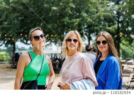 Portrait three cheerful young adult women friend walk street old european german town city street park enjoy have fun laughing sunny day together. Female persons friendship celebration party weekend Portrait three cheerful young adult women friend walk street old european german town city street park enjoy have fun laughing sunny day together. Female persons friendship celebration party weekend 118182934