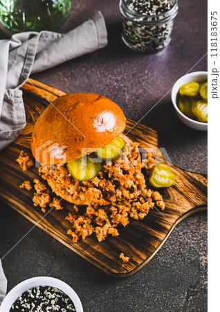 Hearty burger with ground beef and pickles on a board on a table vertical view Hearty burger with ground beef and pickles on a board on a table vertical view 118183675