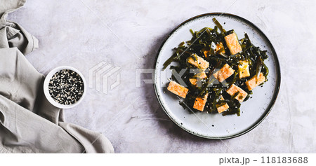 Seaweed salad with fried soy tofu cheese on plate on table top view web banner 118183688