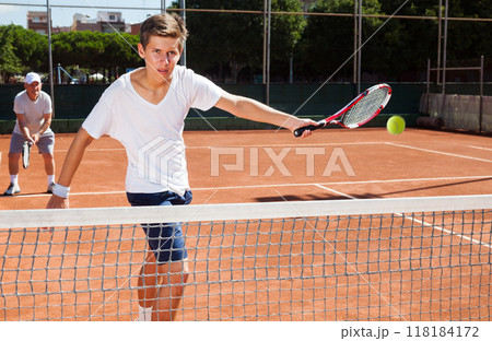 Grandfather and grandson playing tennis court Grandfather and grandson playing tennis court 118184172