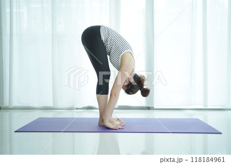 Asian woman practices yoga exercise at home. Asian woman practices yoga exercise at home. 118184961