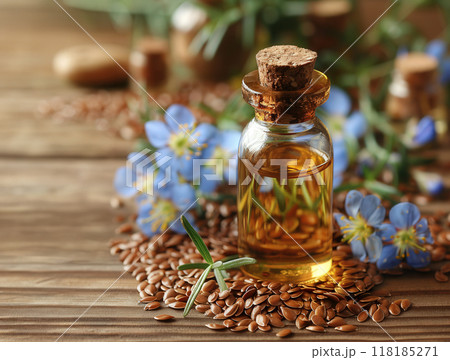 Bottle flaxseed oil surrounded flax seeds and blue flax flowers, with rustic wooden background. 118185271
