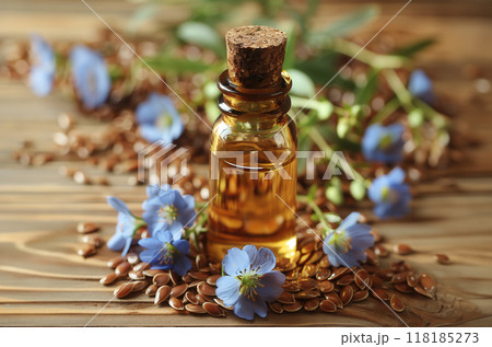 Bottle flaxseed oil surrounded flax seeds and blue flax flowers, with rustic wooden background. 118185273