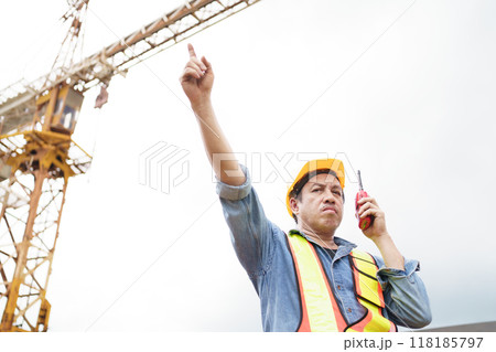 Careless worker at construction site without wearing helmet. 118185797