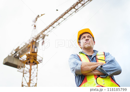 Careless worker at construction site without wearing helmet. 118185799