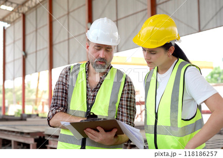 Team of workers at construction site with heavy machines. 118186257