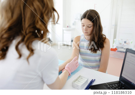 Doctor doing skin allergy test at white table in office. Allergy test - skin prick allergy testing for possible allergens Doctor doing skin allergy test at white table in office. Allergy test - skin prick allergy testing for possible allergens 118186310