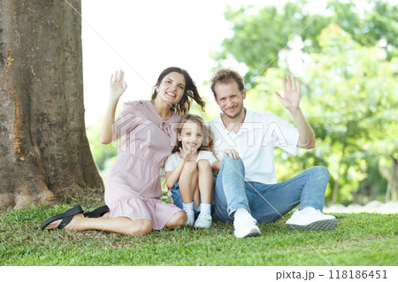 Happy family relaxing together at the park, caucasian family with father, mother, and children walking at the park. Happy family relaxing together at the park, caucasian family with father, mother, and children walking at the park. 118186451