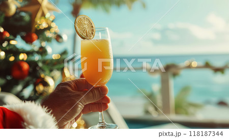 Santa's Hand Holding Festive Cocktail on Tropical Beach, Christmas Vacation and Holiday Cheer Concept 118187344
