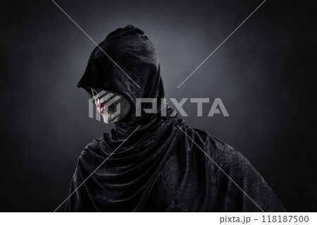 Scary figure with hooded cloak in the dark 118187500