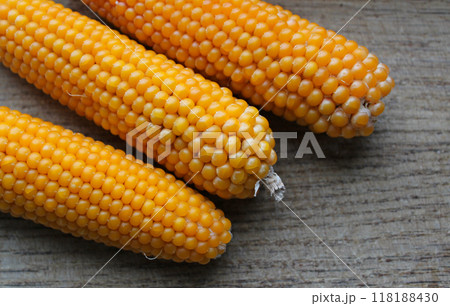 Three cobs of durum corn on a wooden board 118188430