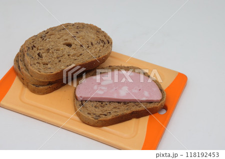Sliced boiled delicious sausage on a white background, sausage sandwich, proper nutrition. Sliced boiled delicious sausage on a white background, sausage sandwich, proper nutrition. 118192453